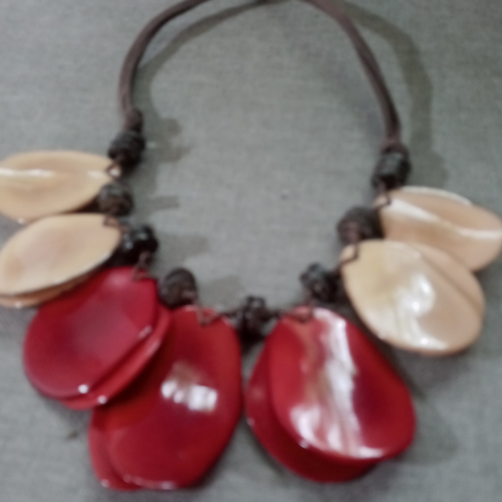 Red and cream color choker on brown leather